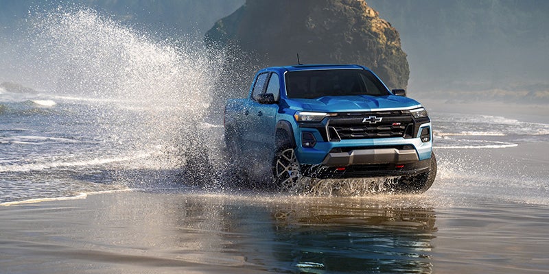 2025 Chevrolet Colorado driving through shallow water on a beach