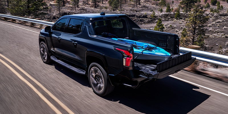 2024 Chevy Silverado EV Driving Down a Highway With A Kayak In The Bed