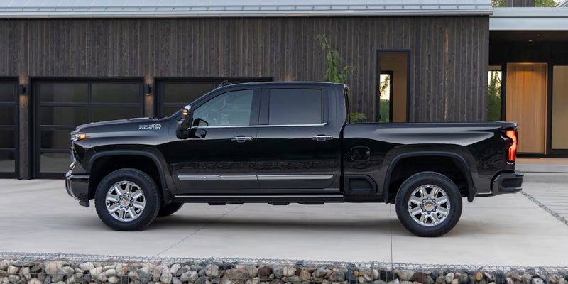 The 2024 Black Silverado HD Displayed Outside of A Modern Ranch Home
