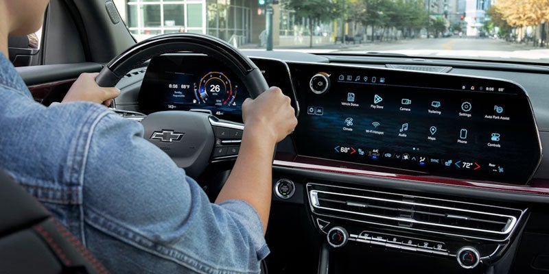 A Man in the Driver’s Seat of 2025 Chevy Traverse Holding the Steering Wheel