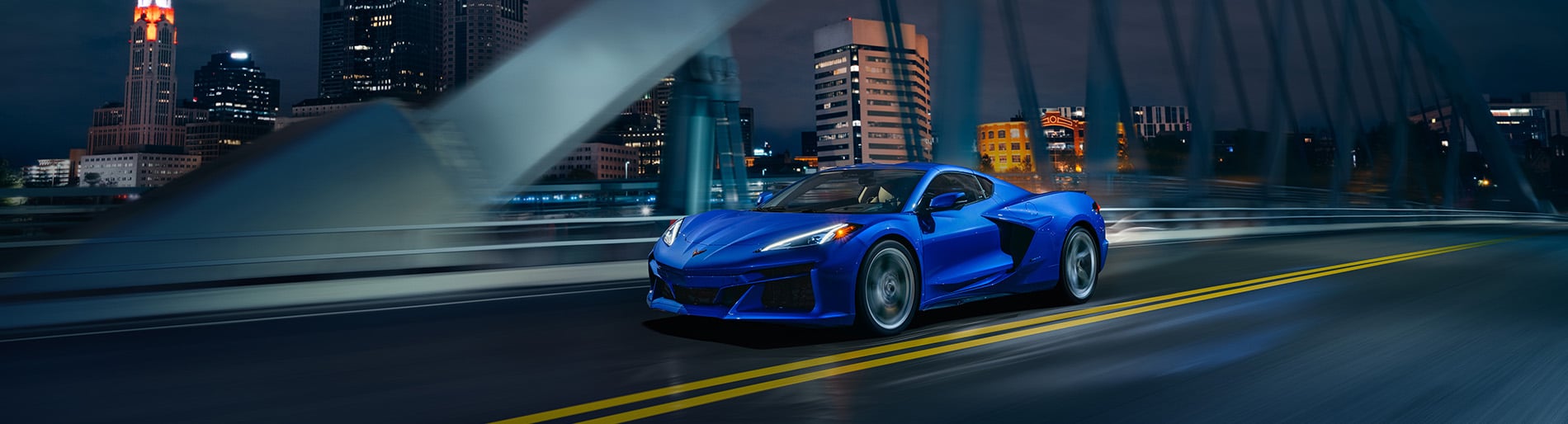 2024 Chevrolet Corvette E-Ray driving on a city bridge a night