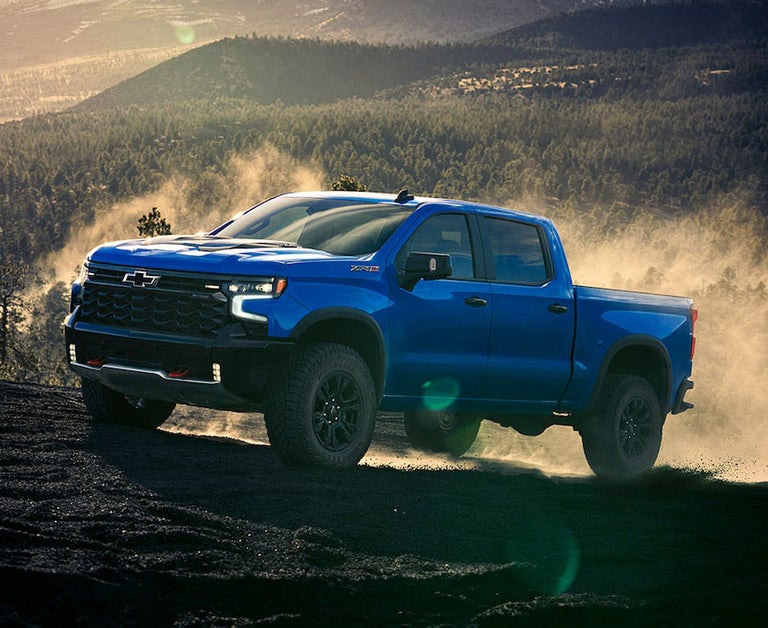 Side view of a 2025 Chevrolet Silverado LD ZR2 in Riptide Blue up a mountain