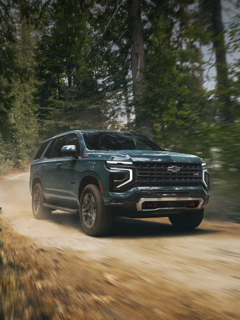 Front Side View of the 2025 Chevrolet Tahoe SUV Driving on a Gravel Path